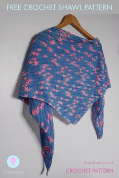 a blue shawl with pink flowers is hanging on a wooden hanger and has the words free crochet shawl pattern