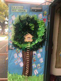 a door decorated with a tree and a house made out of paper mache leaves