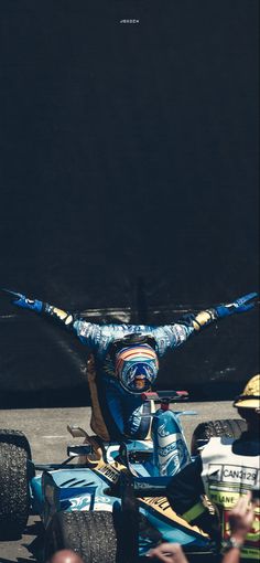 a man riding on the back of a blue race car