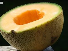 a cut in half melon sitting on top of a wooden table