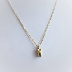 "Tiny 14mm x7mm gold finished or raw pewter tooth charm, on dainty gold tone stainless steel chain, with 1\" extension chain, and lobster clasp closure. These are permanently attached to the necklace and cannot be removed without jewelry plyers. *Please note these will have seams and some extra bits between the 'roots' of the tooth (this is from the manufacturing and casting process* ..: V I E W S H O P:.. www.lotusfairy.etsy.com www.shopEarthshine.com ..: P O L I C I E S :.. Please see the drop down FAQs menu All items are FINAL SALE. ★ I M P O R T A N T ★ This product is not intended to be used by, or around,  anyone under the age of 13.  ShopEarthshine.com ★ lotusfairy.etsy.com  Canadian buyers:  Prices shown include GST/HST." Gold Tooth, Cute Finger Tattoos, Tooth Charm, Gold Teeth, Tooth Necklace, Brass Chain, Pretty Jewellery, Steel Chain, Stainless Steel Chain