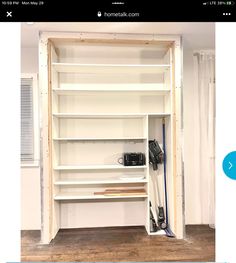 an empty room with shelves and tools on the floor in front of a white wall