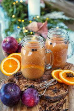 two mason jars filled with liquid sitting on top of a cutting board next to fruit