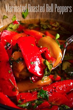 a close up of food in a bowl with a spoon on the side and text overlay that reads marinated roasted bell peppers