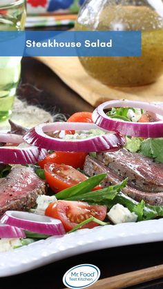 steakhouse salad with tomatoes, onions, lettuce and feta cheese on a white plate