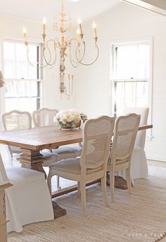 a dining room table with chairs and a chandelier