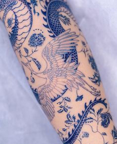 the arm is covered with blue and white tattoos on it's arms, which are decorated with birds and flowers