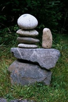 some rocks stacked on top of each other in the grass