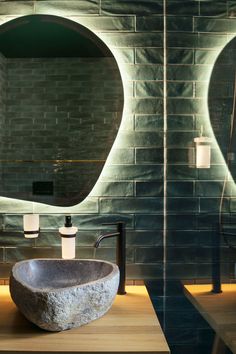 a bathroom sink sitting next to a mirror in front of a wall mounted faucet