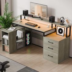 a computer desk with a keyboard and monitor on top of it next to a potted plant