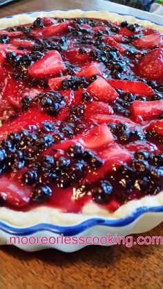 a pie with blueberries and strawberries on it