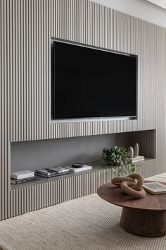 a living room with a large flat screen tv mounted on the wall next to a coffee table