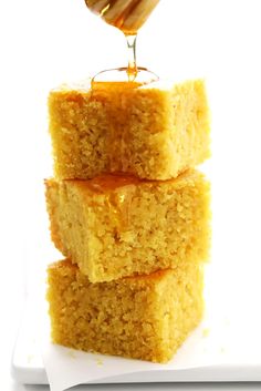 honey being drizzled over three squares of cake