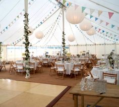 the inside of a tent with tables and chairs set up for a wedding or party