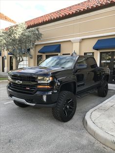 a black truck parked in front of a building