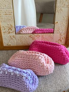 three crocheted purses sitting on top of a bench in front of a mirror