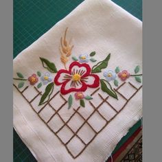 a close up of a piece of cloth with flowers and leaves embroidered on the side