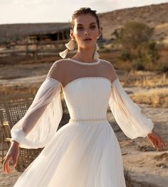 a woman in a white dress is posing for the camera