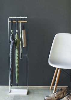 a white chair sitting next to a rack with umbrellas