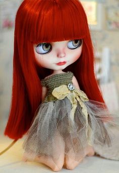 a doll with red hair wearing a dress