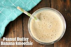 peanut butter banana smoothie in a glass on a wooden table with a green towel