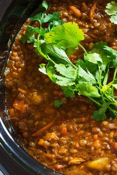 a crock pot filled with beans and cilantro garnished with parsley