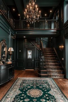 an elegant entryway with chandelier and rug on the hardwood flooring in front of it