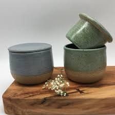 two ceramic bowls sitting on top of a wooden board