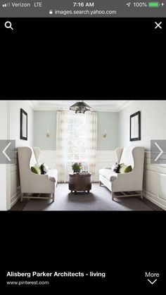 a living room with two white chairs and a coffee table