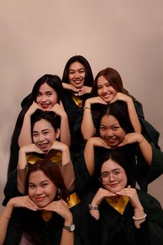 a group of women in graduation gowns posing for a photo with their arms around each other