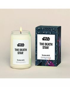 a candle that is next to a box with the words star wars on it and an image of darth vader