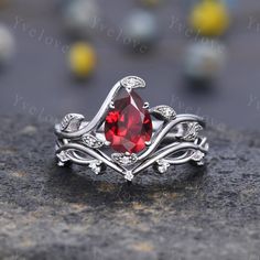 a close up view of a ring with a red stone