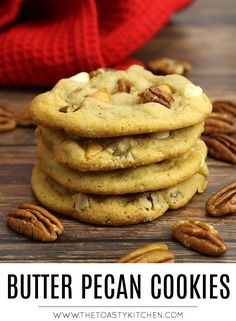 a stack of butter pecan cookies on top of a wooden table with pecans