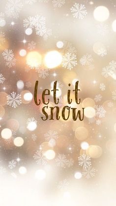 the words let it snow are written in gold and white on a blurry background