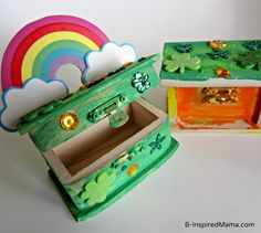 two small wooden boxes decorated with shamrocks and a rainbow