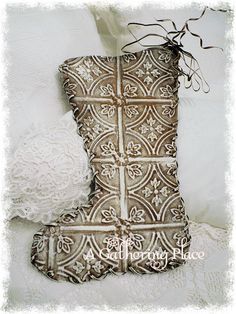 an old fashioned boot is sitting next to a lace doily on a white sheet