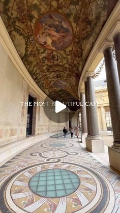 the inside of an ornate building with columns and paintings on the ceiling, along with marble flooring