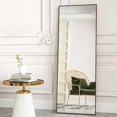 a mirror sitting on top of a table next to a chair