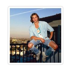 a young man sitting on top of a balcony next to a railing with an airplane in the background