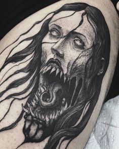 a man's thigh with a black and white drawing of a demon on it