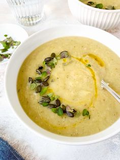 two white bowls filled with soup on top of a table