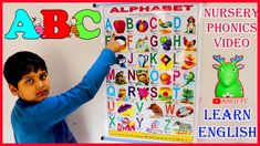 a young boy writing on a white board with alphabets and numbers in front of him