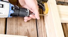 a person using a power drill on wood planks