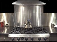 a stainless steel stove top oven with two burners and four burners on each side