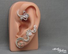 Wire wrapped crystal steampunk ear wrap in silver, no piercing required. It's made of nickel free silver plated wire, a recycled stainless steel watch wheel, seed beads and white swarovski crystal beads. Available: - left ear - right ear - pair Plz, select from the list (select style). You can find more ear wraps here: https://www.etsy.com/shop/bodaszilvia?section_id=10953132&ref=shopsection_leftnav_4 Plz, read my policies before buying. Thank you! If you are interested in news, work in progress Unique Silver Adjustable Body Jewelry, Adjustable Nickel-free Silver Wrap Earrings, Unique Silver Metal Ear Cuff, Unique Sterling Silver Body Jewelry Gift, Unique Sterling Silver Body Jewelry For Gifts, Unique Sterling Silver Body Jewelry In Silver, Unique Handmade Body Jewelry For Weddings, Silver Wire-wrapped Metal Cartilage Earrings, Silver Wire Wrapped Metal Cartilage Earrings