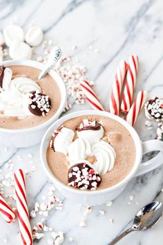 two white cups filled with hot chocolate and marshmallows