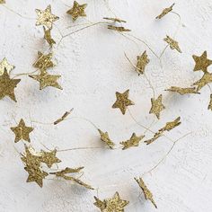 some gold stars are hanging on a white wall