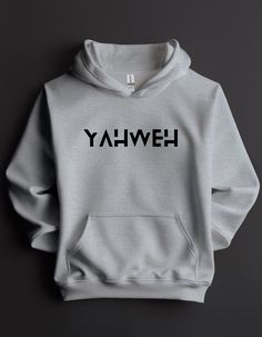 Step into the profound with our Men's YAHWEH Hooded Sweatshirt, a garment that goes beyond fashion, representing the sacred name of God. Linked to how God described Himself in Exodus 3:14 — "I AM WHO I AM" — this hoodie serves as a tangible reminder of the divine nature of God. YAHWEH is more than just a combination of letters; it is the essence of God's identity. Every time you wear this hoodie, let it be a profound reflection of the divine, a connection to the self-existent and eternal nature Christian Merch Ideas, God Clothing, Jesus Graphic, Christian Clothing Brand, Exodus 3, Jesus Clothes, Name Of God, Christian Shirts Designs, Nature Of God