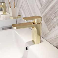 two gold faucets on a white sink in a bathroom