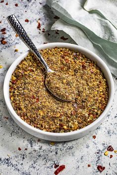 a white bowl filled with granola on top of a table next to a spoon